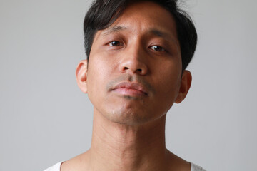 Obraz premium Serious asian man posing over white background looking at the camera.