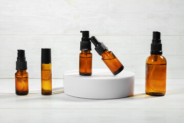 Amber bottles with facial liquid and a linen towel on wooden table