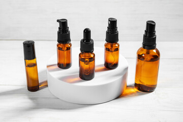 Amber bottles with facial liquid and a linen towel on wooden table