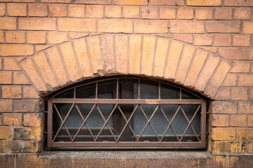 A barred window in the basement of a historic building