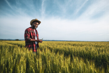 Young farmer is examining crops in his growing wheat field.	