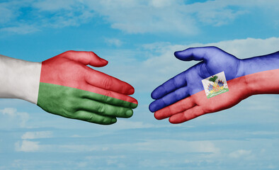 Haiti and Madagascar country handshaking with flags, consensus concept international co-operation illustration