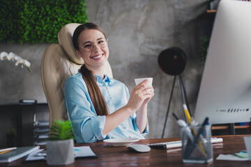 Photo of cheerful positive lady recruiter dressed shirt eyewear drinking coffee working modern...