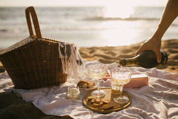 Beautiful summer picnic with champagne at sunset on the beach. © polinaloves
