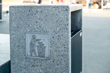 Public trash can on a city street filled with garbage.