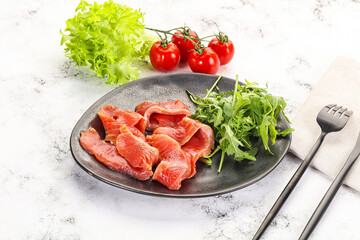 Sliced salmon with fresh arugula