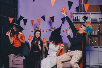 Obraz premium Joyful office Halloween party with coworkers in costumes, celebrating with drinks and laughter, fostering teamwork and festive spirit