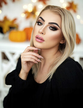 Portrait einer sch&ouml;nen blonden Frau mit perfektem Permanent Make-Up und Gel-Fingern&auml;geln mit herbstlichen Bl&auml;ttern