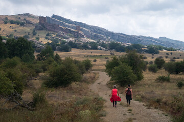 Obraz premium Dos mujeres senderistas caminan por la sierra de Caldereros hacia el castillo de Zafra, Campillo de Dueñas, Guadalajara, España.