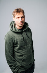 Obraz premium Casual portrait of a man in a green hoodie indoors.