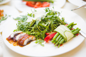 Roasted duck salad with greens served.