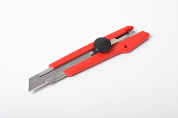 Red utility knife cutter isolated on white background. Stationery cutter knife