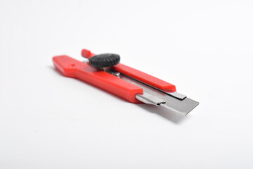 Red utility knife cutter isolated on white background. Stationery cutter knife