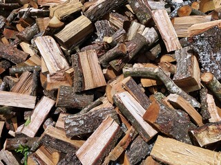 Firewood background concept: a pile of chopped oak wood ready to be used in wood stoves and fireplaces