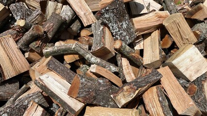 Firewood background concept: a stack of oak wood cut and ready to be burned in wood-burning stoves and fireplaces.