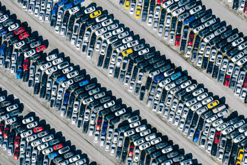 Aerial drone view of Parking lot. New cars storage area. Many cars parked in a rows