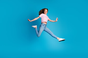 Obraz premium Full length photo of lovely young lady running hurry dressed stylish striped pink garment isolated on blue color background
