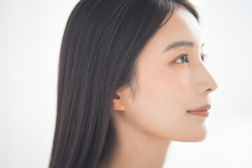 Naklejka premium Portrait of a young beautiful Asian woman. She has straight black hair.