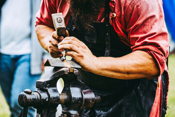 Close-up sur les mains d'un forgeron en train de travailler
