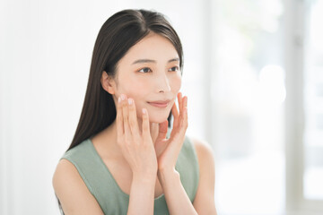 Skin care. Woman with beauty face touching healthy facial skin portrait. Asian woman.	

