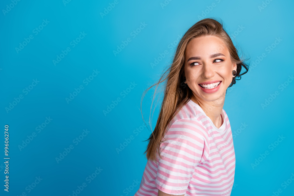 Poster Photo portrait of lovely young lady fluttering hair look empty space dressed stylish striped pink garment isolated on blue color background