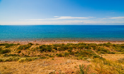 large open water surface with far snowcapped mountain range on the horizon at sunny day.