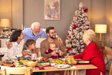 Young couple celebrating Christmas with parents and children at home