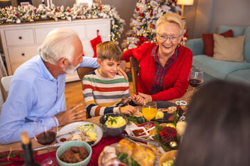 Boy having Christmas dinner with grandparents