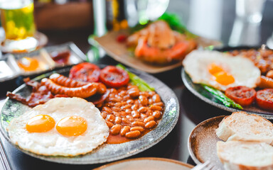 English breakfast menu fried eggs baked beans in tomato sauce and bacon sausage in plate
