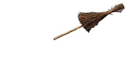 A witches broomstick leaning against a wall placed against a solid black background
