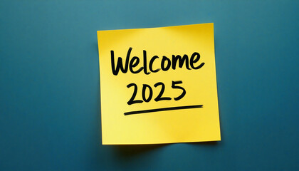 Welcome 2025 saying on yellow sticky note against blue wall