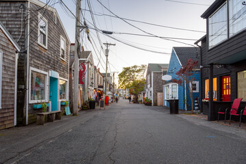 Obraz premium Street lined with traditional American wooden buildings and shops in a fishing village at dusk in autumn