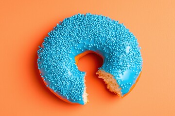 A blue frosted donut with blue sprinkles on top