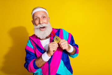 Photo of funky sportive grandfather show golden medal empty space vintage sportswear isolated on yellow color background