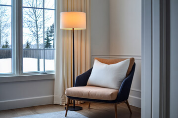 Cozy corner with a stylish chair and lamp in a bright room overlooking a snowy landscape in wintertime