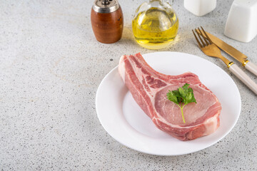 Raw meat diet, Raw Carnivore Animal-based Diet. Plate with tasty spiced meat steak, with cutlery, ready for eating, copy space