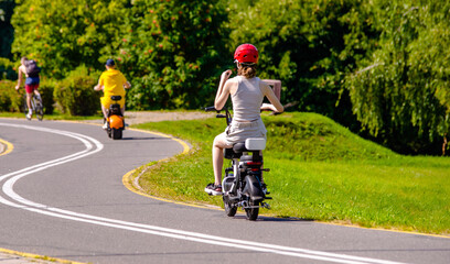Fototapeta premium A woman rolls on an electric scooter in the Park 