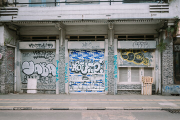 Vandalism artwork spray-painted on a residential house wall, displaying bold, unauthorized graffiti