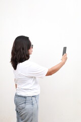 Fototapeta premium Rear view of Asian corporate woman taking photo with mobile phone. Isolated on white background.