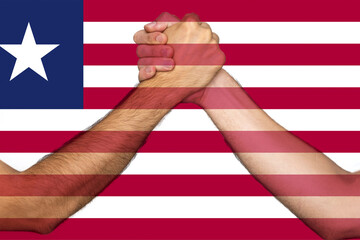 Two hands gathering front of Liberia flag, union of society, togetherness and solidarity concept