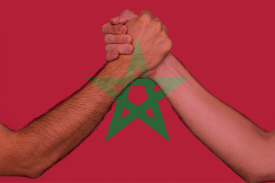 Two hands gathering front of Morocco flag, togetherness and solidarity concept, human rights, help 