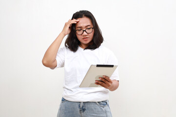 Fototapeta premium Portrait of asian business woman looking at digital tablet with worried, stressed and upset face. Isolated on white