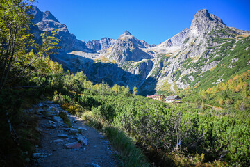 Scenic view of a hiking path leading through a valley to a mountain lodge in the high tatras mountains