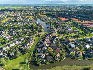 Aerial drone image of c new houses with red tiled roof and solar pv panels in Sneek, the netherlands