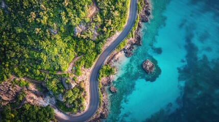 Aerial view of a winding coastal road bordered by vibrant greenery and clear blue waters highlighting a stunning landscape ideal for travel and exploration