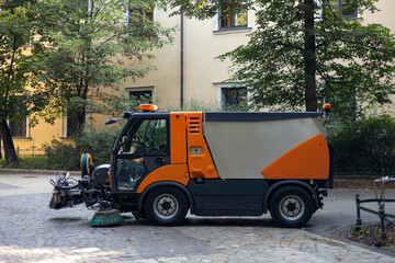 Municipal car for cleaning and brush roads or sidewalks outdoors. Steel Broom of Road Sweeper Car...