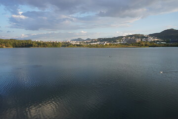 Grande parco di tirana al tramonto, vista su lago, alberi e montagne