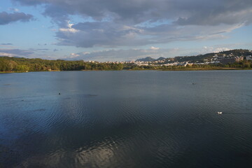 Grande parco di tirana al tramonto, vista su lago, alberi e montagne