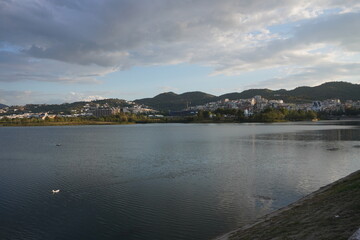 Grande parco di tirana al tramonto, vista su lago, alberi e montagne