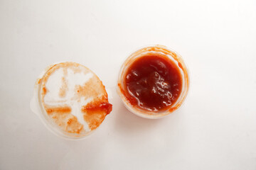 Small container filled with chili sauce. Isolated with white background